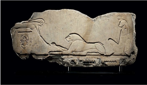 Lot 30. AN EGYPTIAN LIMESTONE RELIEF  PTOLEMAIC PERIOD, 304-30 B.C.  Sculpted in sunk relief, the sky goddess Nut to the left arching over a horizontal line representing Geb, the earth god, and the god Khepri, in the form of a scarab beetle, a lion to the right with its right forepaw raised, representing Horakhty, and Isis seated to the right, looking left, all on a groundline, the upper portion of a hieroglyphic inscription below 19 in. (48.2 cm.) wide  Estimate: $20,000-30,000 Click on image to enlarge.